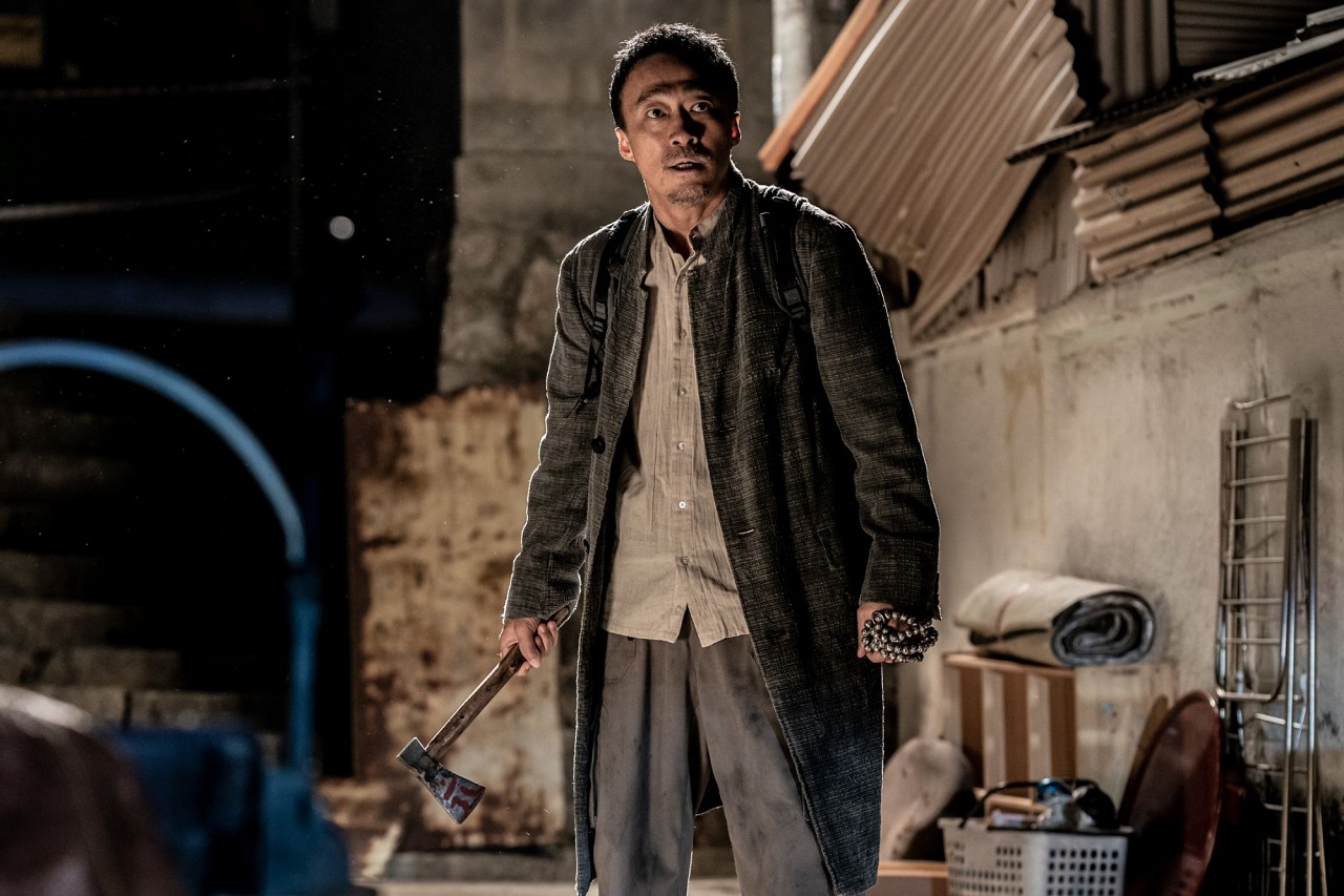 Priest Lee Sung-min with his axe coated with symbols in blood in The 8th Night (2021)