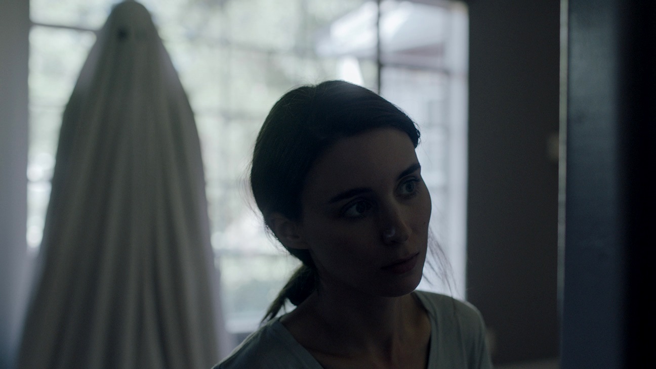 The ghost of C (Casey Affleck) hovers invisibly behind his widow M (Rooney Mara) in A Ghost Story (2017)