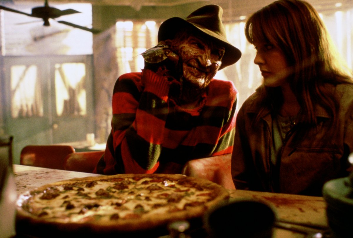 Freddy Krueger (Robert Englund) sits down to enjoy a pizza with Alice Johnson (Lisa Wilcox) in A Nightmare on Elm Street IV: The Dream Master (1988)