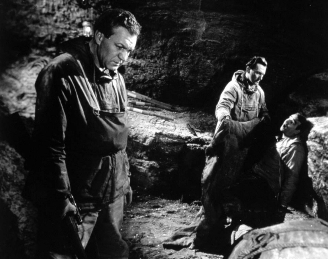 (l to r) Expedition leader Forrest Tucker while in the background Peter Cushing tends a wounded Robert Brown in The Abominable Snowman (1957)