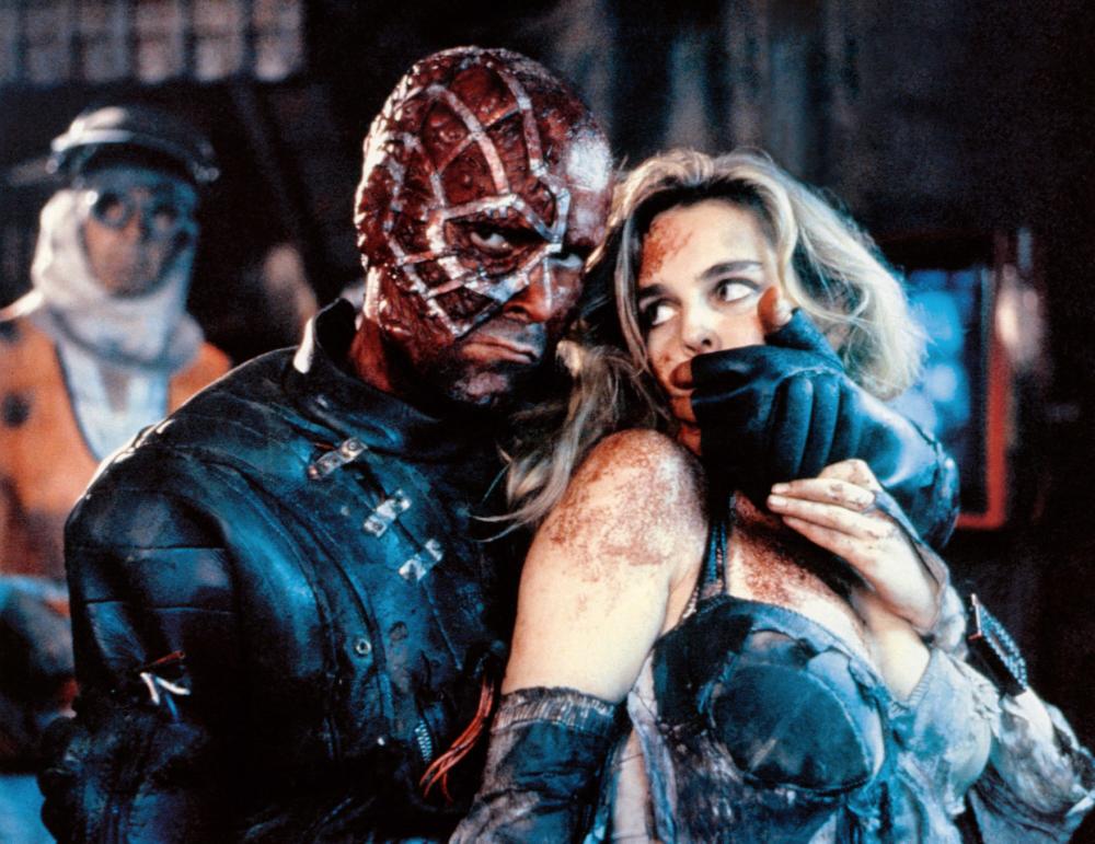 Mutant terrorist leader Ramon Yrritu (Antonio Resines) with his hostage heiress Frederique Feder in Accion Mutante (1993)