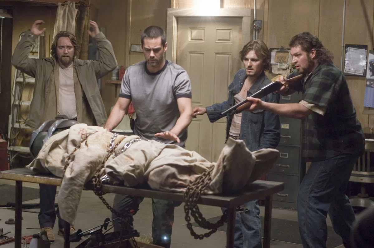 Four friends with a captured alien in their garage - (l to r) Paul McCarthy-Boyington, Adam Kaufman, Mike C. Williams and Brad William Henke in Altered (2006)