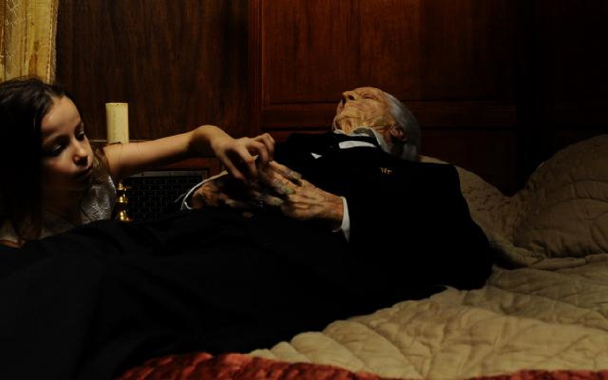 Young Ana (Cassandra Foret) tries to take the pocket watch from the corpse of her grandmother in the first episode of Amer (2009)