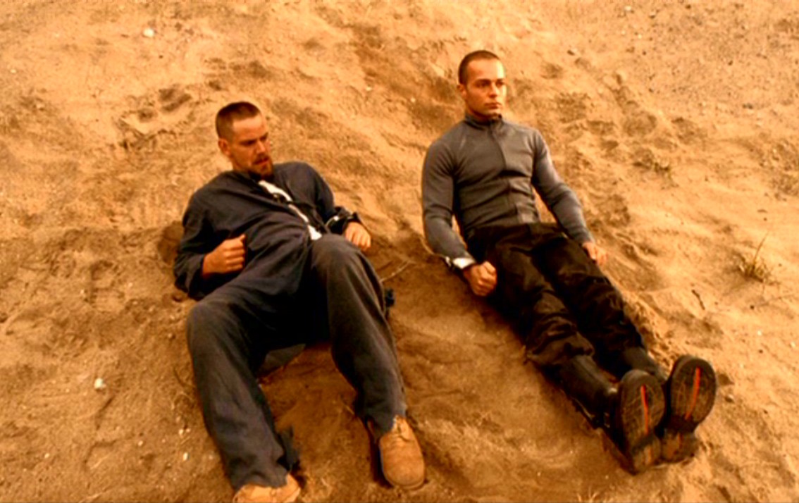 (l to r) Human Scott Bairstow and android Joseph Lawrence chained together in the desert in Android Apocalypse (2006)