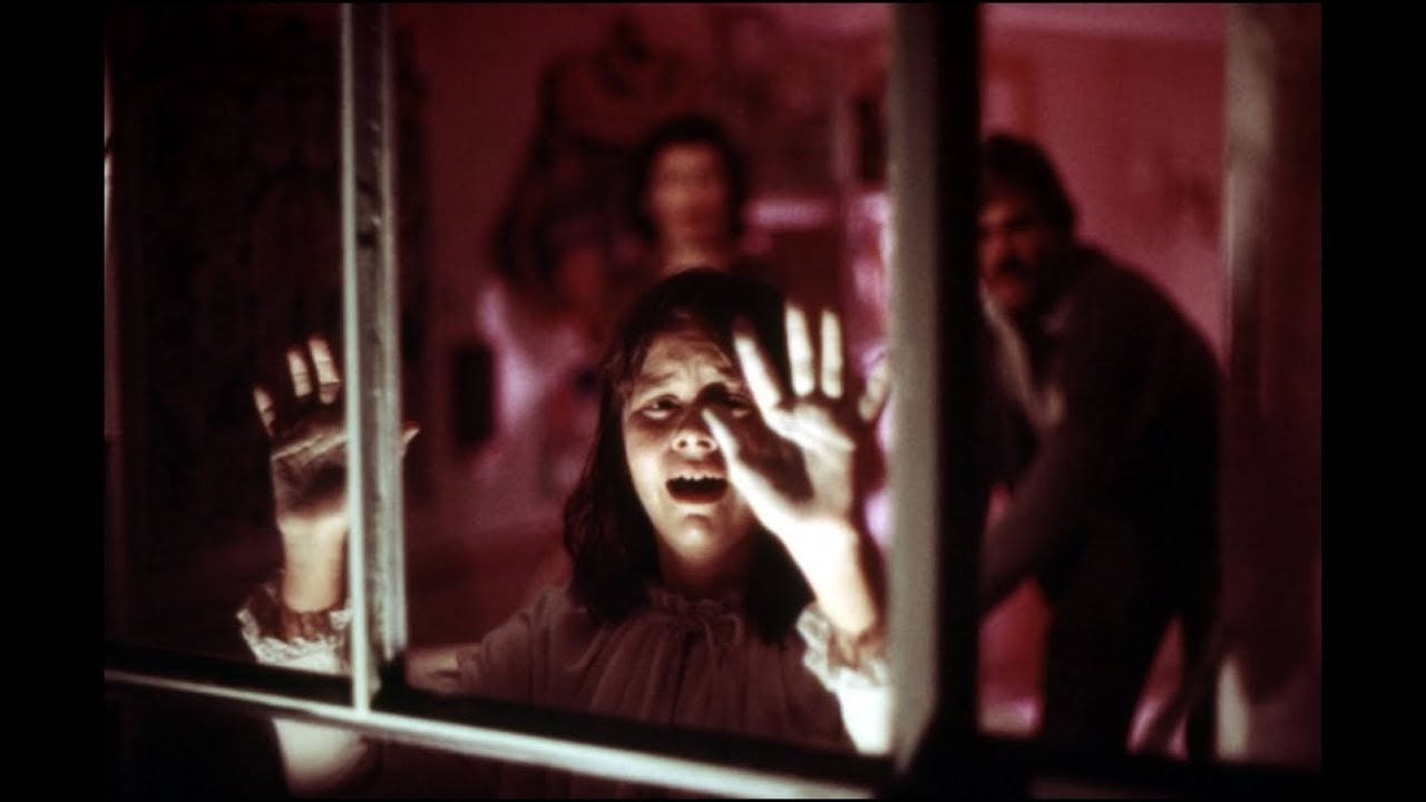 A terrified Ivy Templeton (Susan Swift) with parents Marsha Mason and John Beck (out of focus in background) in Audrey Rose (1977)