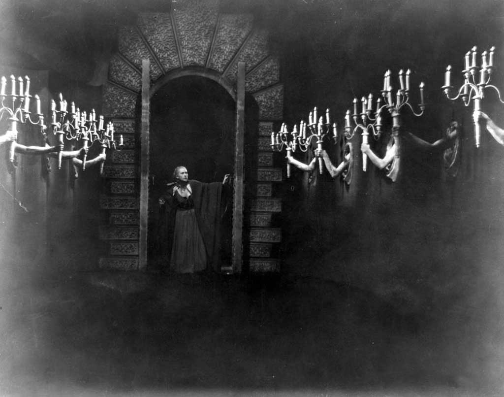 Beauty (Josette Day) walks own the hall of candelabra held by living hands in Beauty and the Beast (1946)