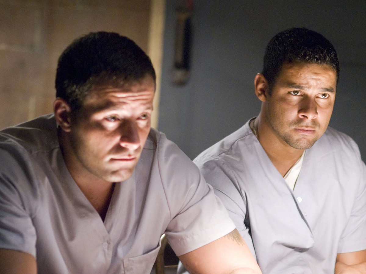 Abducted paramedics Johnny Messner, Jon Huertas in Believers (2007)