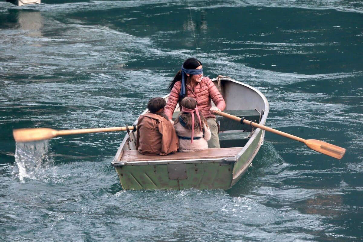 Sandra Bullock and the children try to make it down river to sanctuary by canoe while blindfolded in Bird Box (2018)