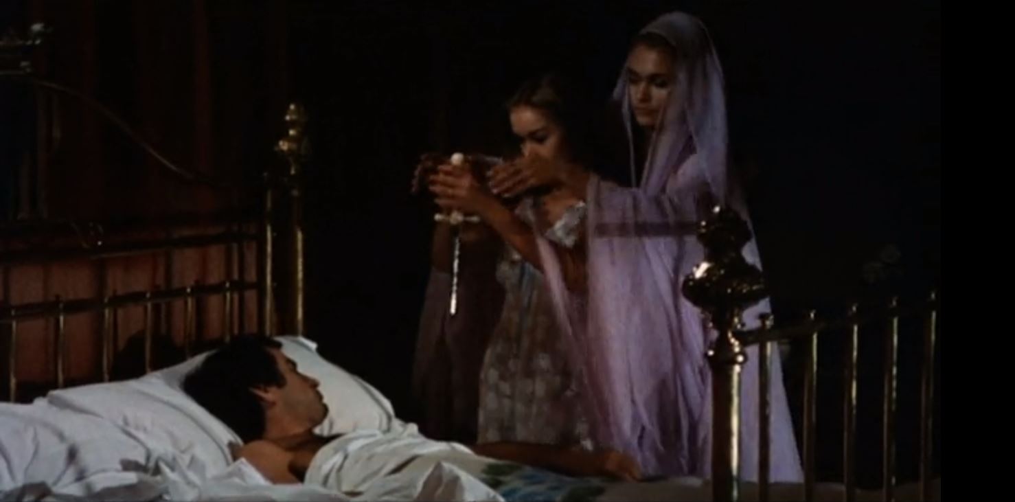 Husband Simon Andreu sleeps as wifw Maribel Martin is urged to castrate him by Carmilla (Alexandra Bastedo) in The Blood Spattered Bride (1972)