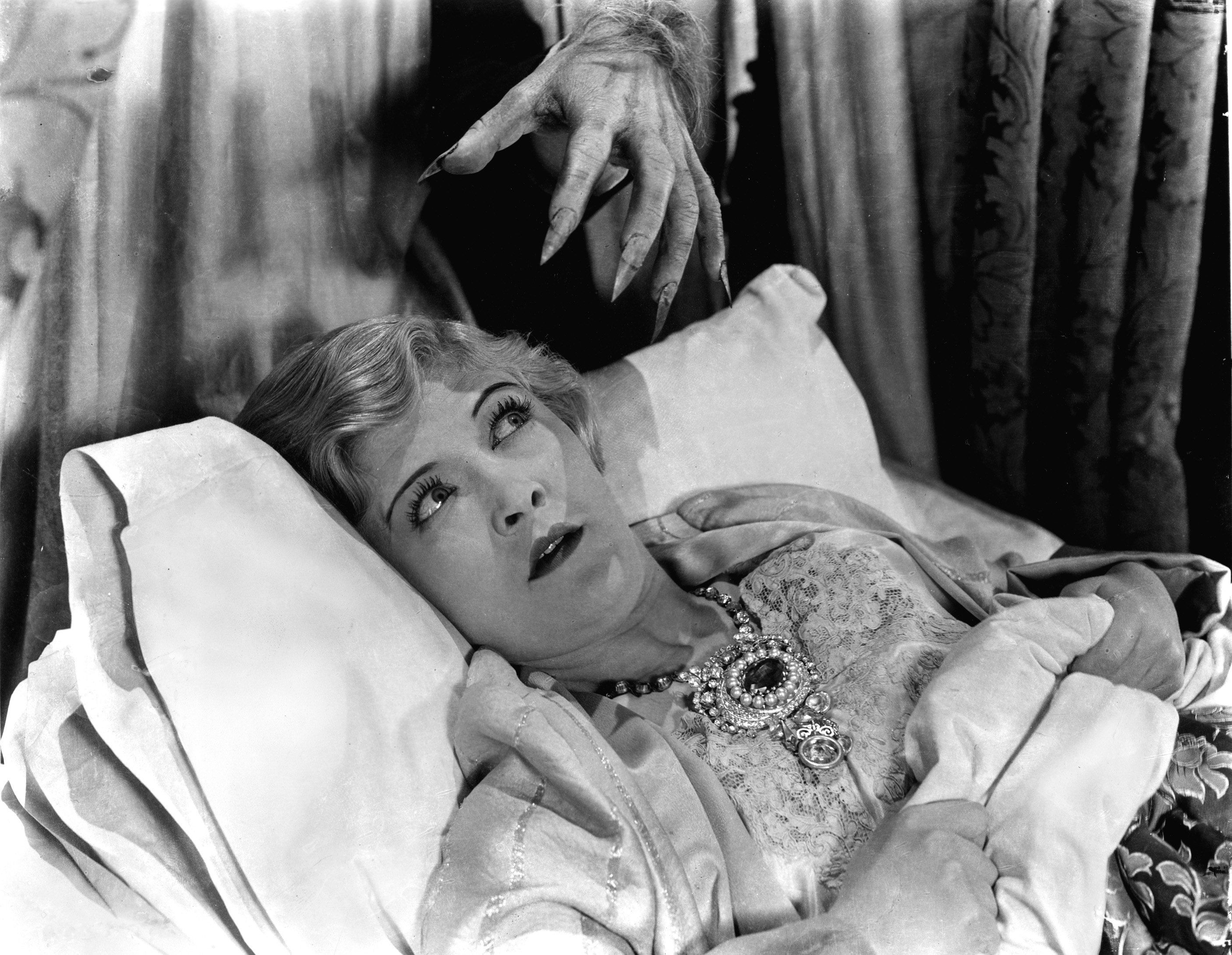 Laura La Plante menaced by a claw from behind a hidden panel in The Cat and the Canary (1927)