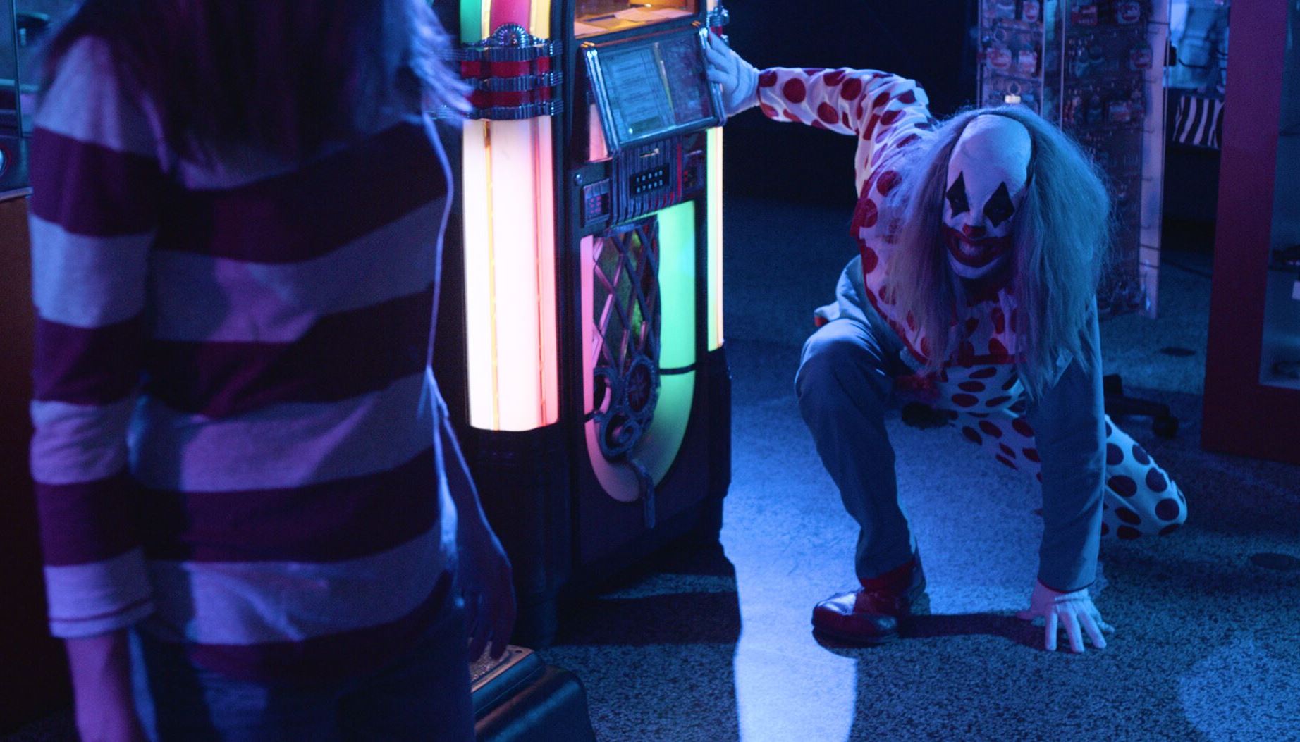 Brittany Belland pursued by Ribcage the clown (Eric Corbin) in Clowntergeist (2017)