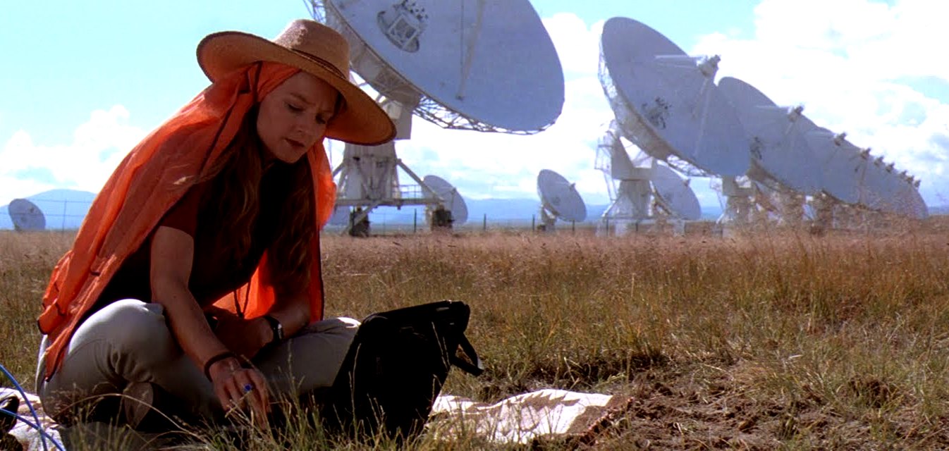 Ellie Arroway (Jodie Foster) listens to the stars in front of the Siccoro radio telescope array in Contact (1997)