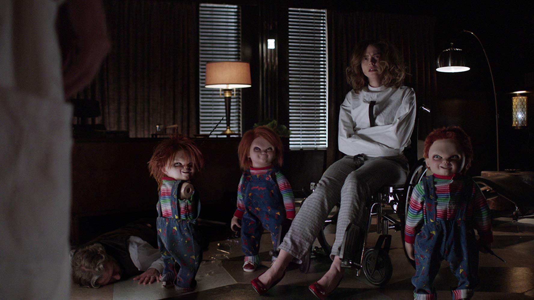 An incarcerated Fiona Dourif surrounded by Chucky dolls in Cult of Chucky (2017)