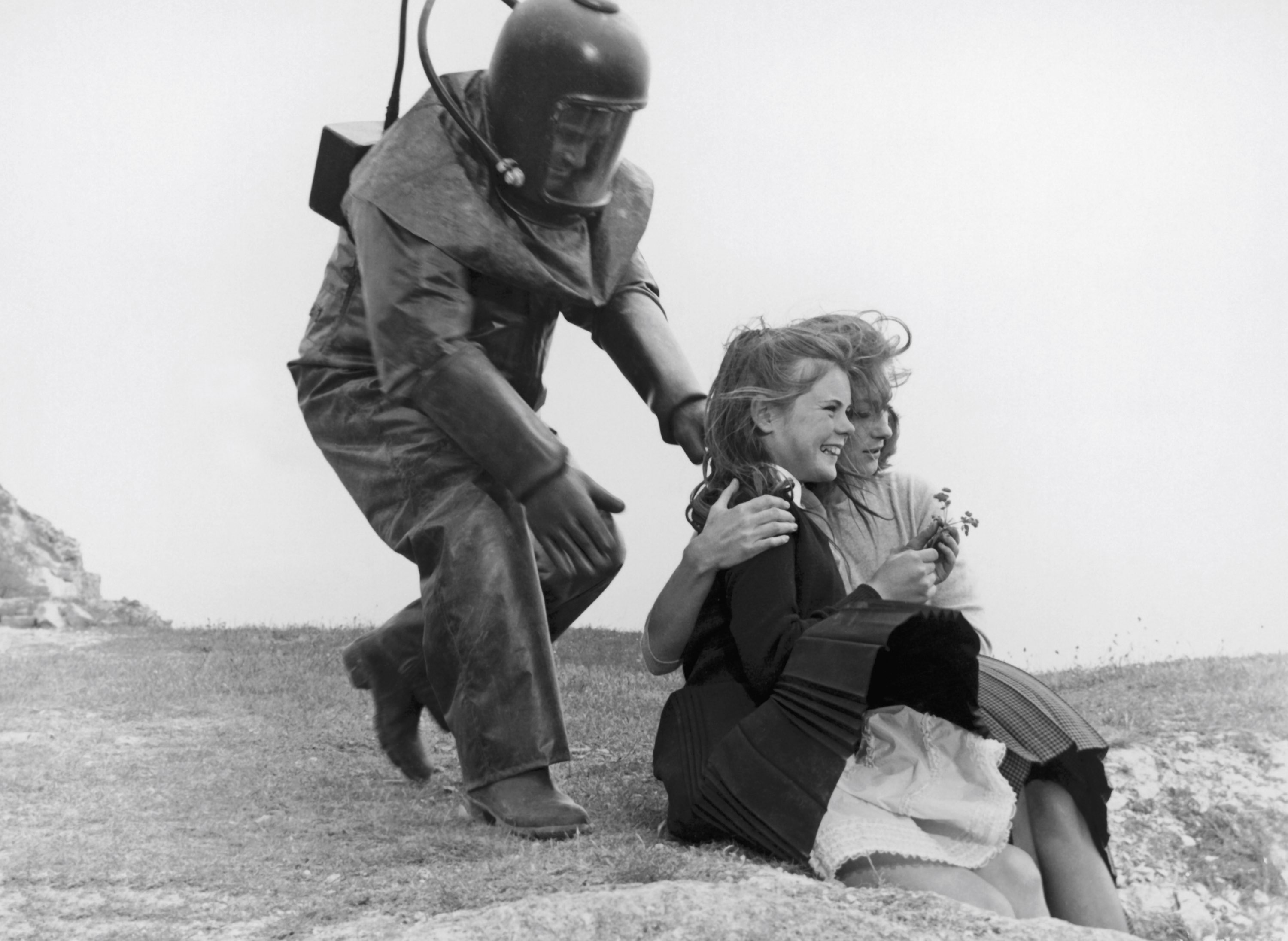 A scientist attempts to recapture one of the radioactive children as she is comforted by Shirley Ann Field in The Damned (1963)
