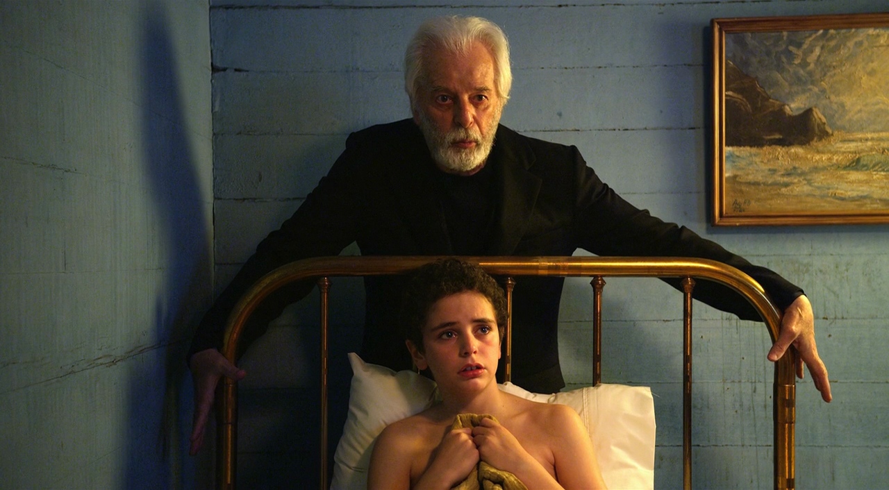 84 tear old director Alejandro Jodorowsky stands over his on-screen childhood self (Jeremias Herskovits) in The Dance of Reality (2013)