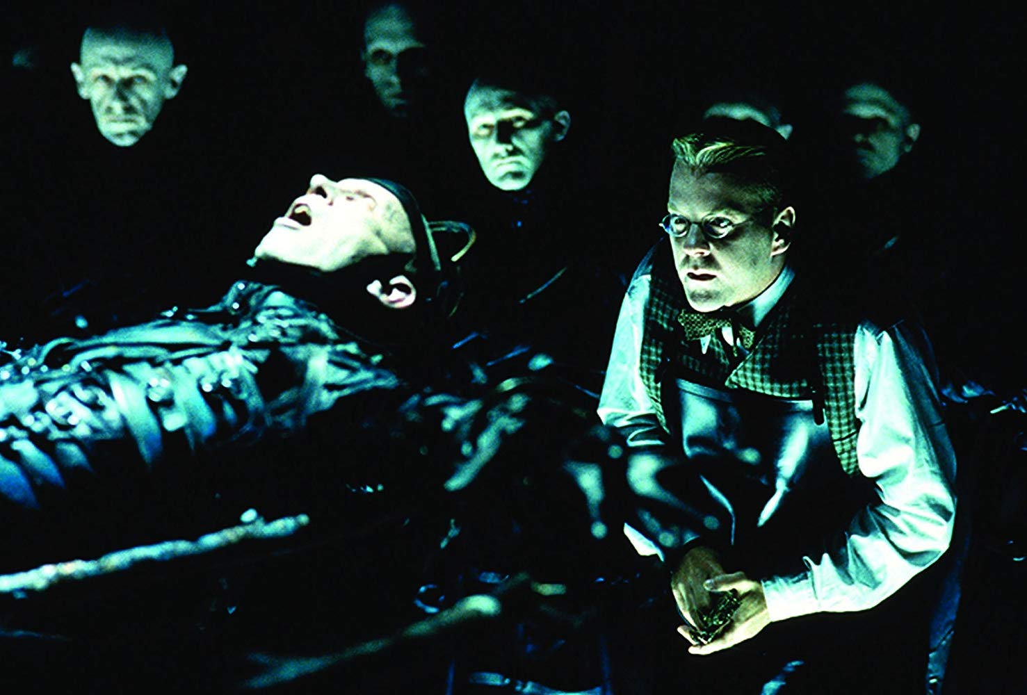 Kiefer Sutherland engaged in experiments surrounded by The Strangers in Dark City (1998)