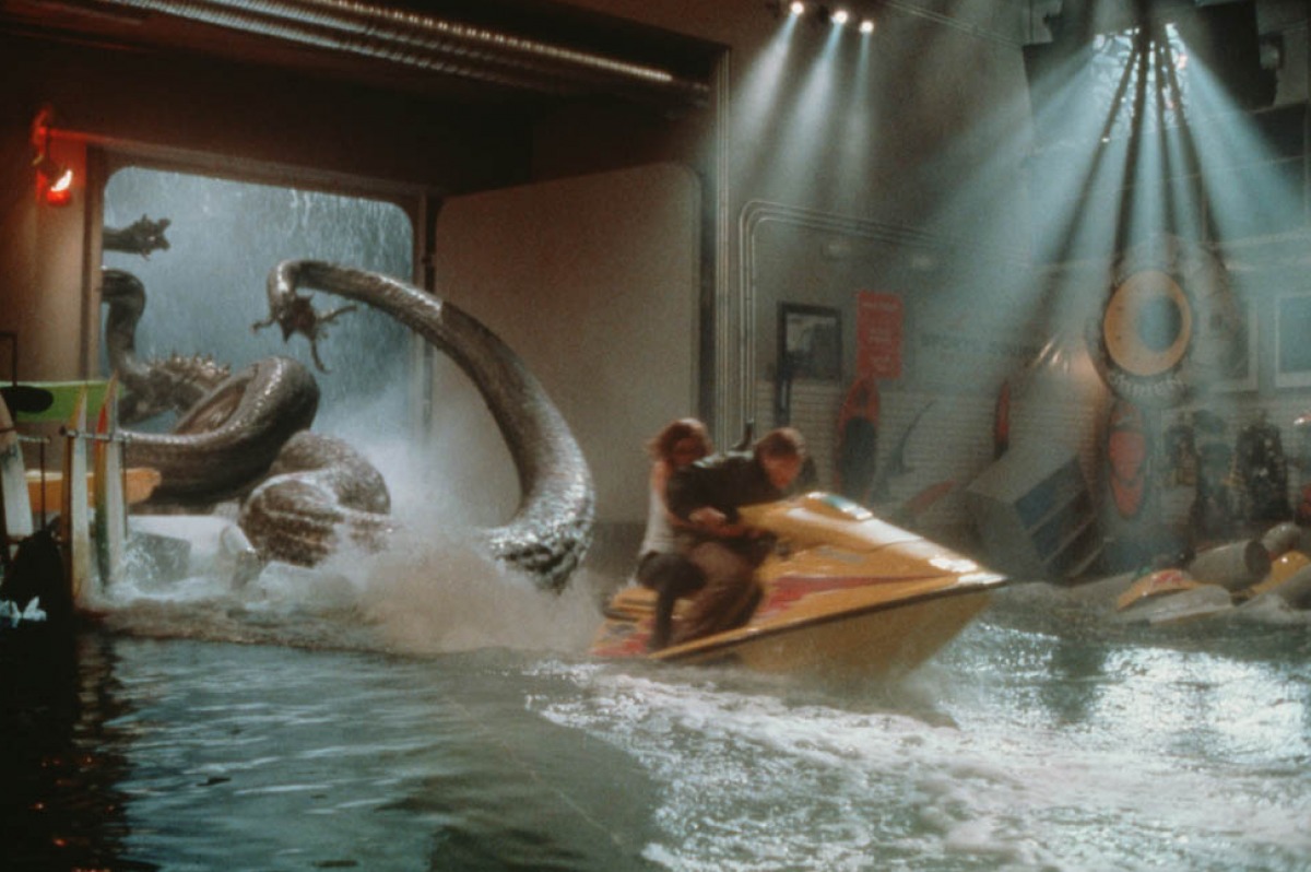 The creature pursues Famke Janssen and Treat Williams as they race through the ship by jetbike in Deep Rising (1998)