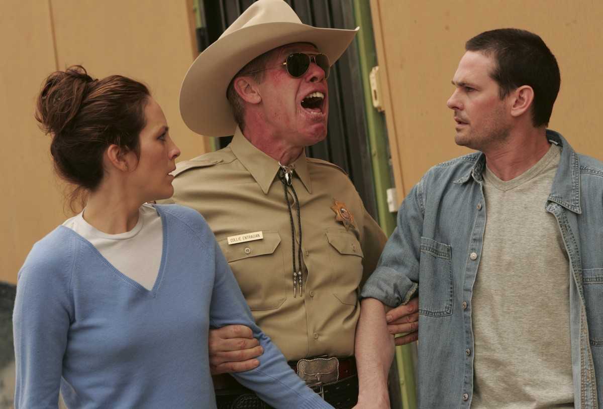 Annabeth Gish and Henry Thomas under arrest by possessed sheriff Ron Perlman in Desperation (2006)