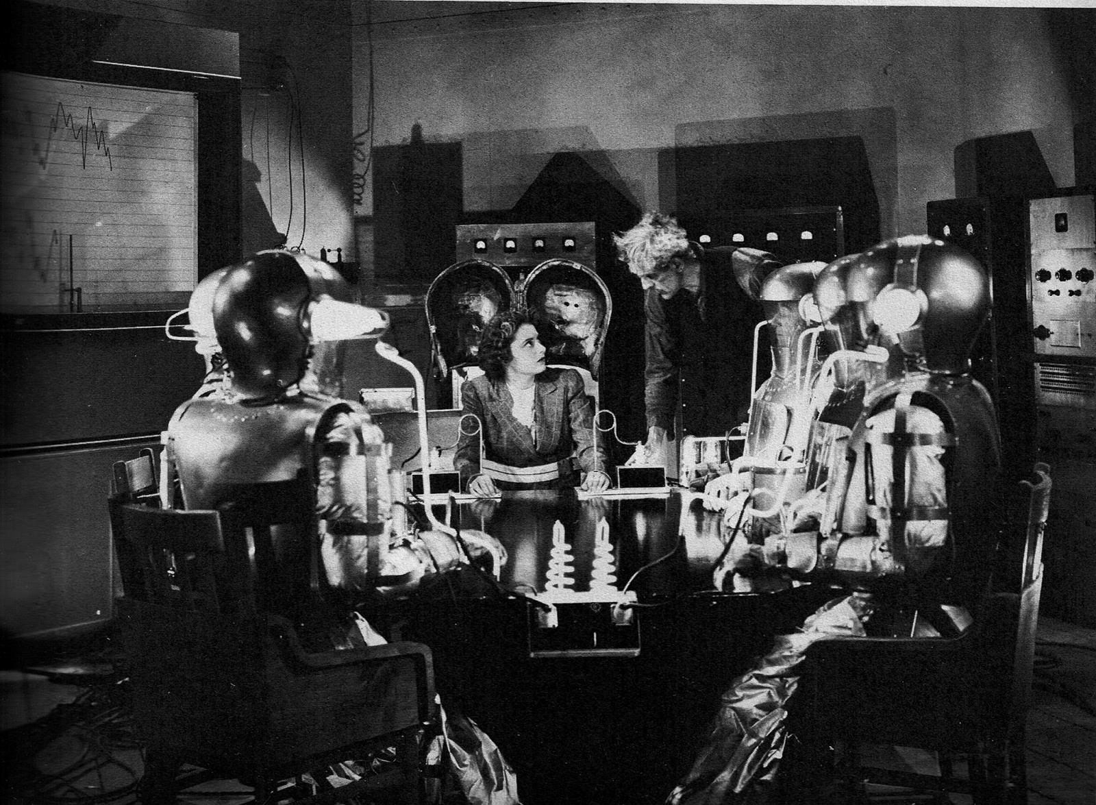 Boris Karloff stands over Anne Revere surrounded by a tableful of corpses as he prepares to conduct his experiment in The Devil Commands (1941)