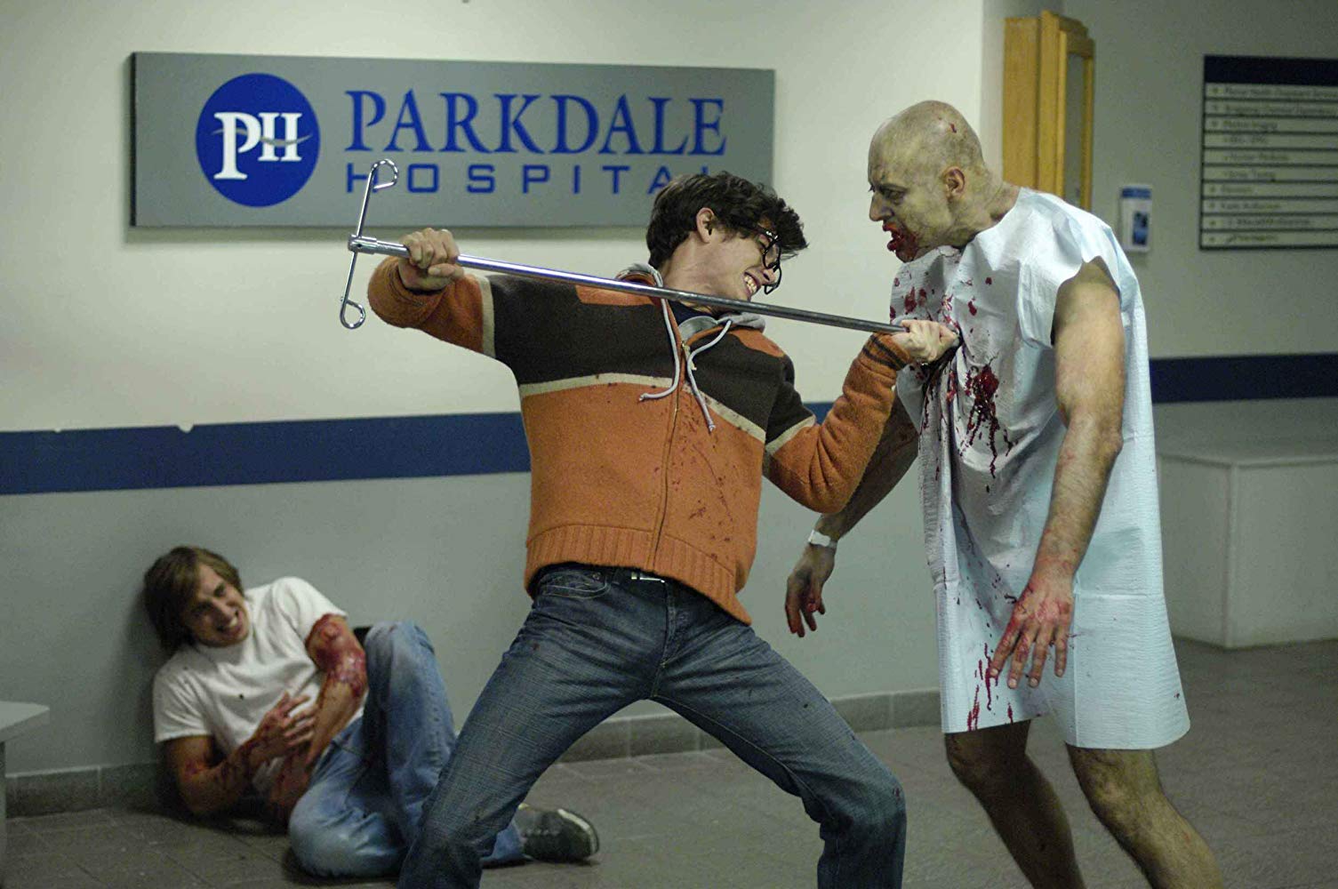 Joe Dinicol fights off a zombie while Chris Violette lies wounded in the background in Diary of the Dead (2007)