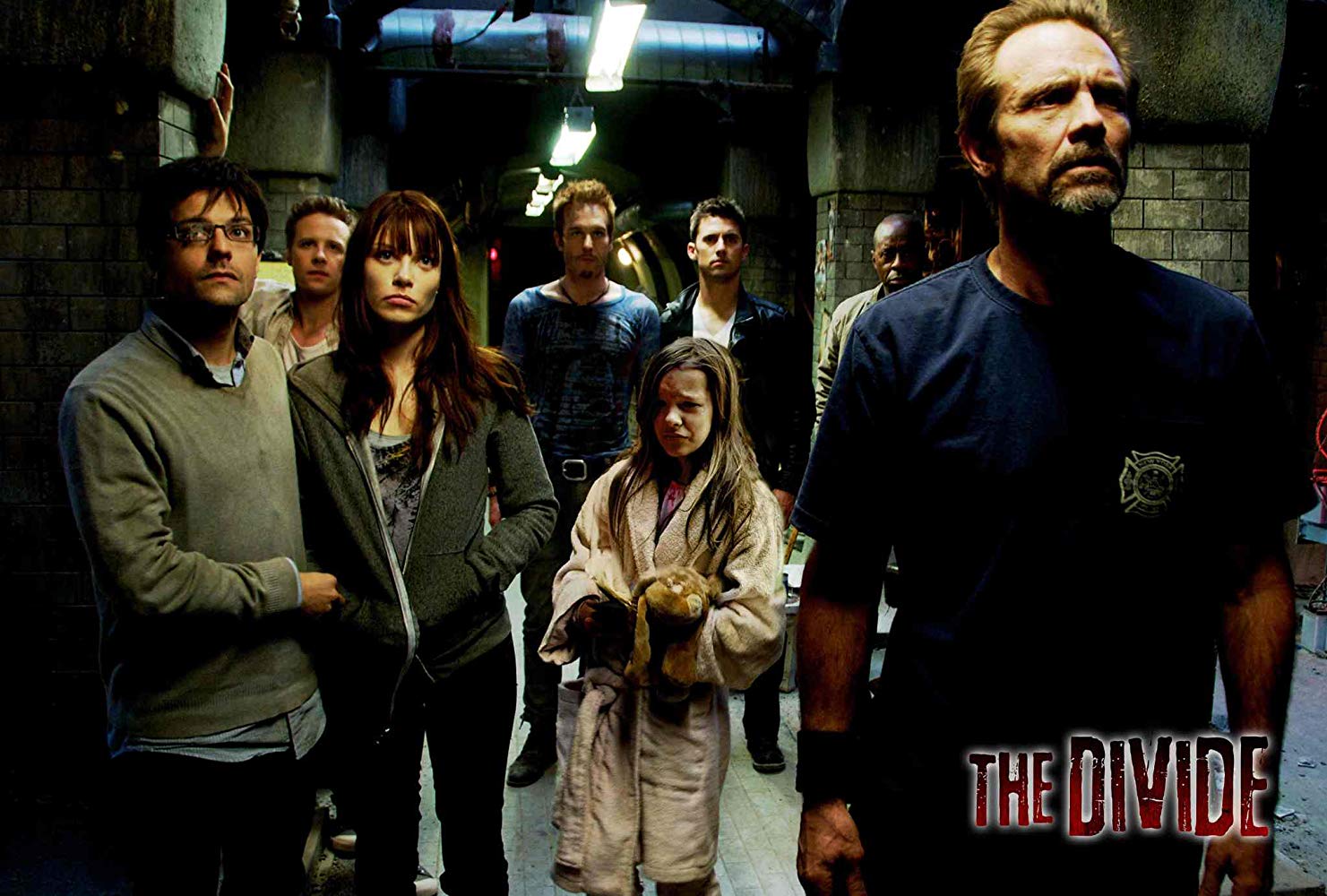 The survivors in the cellar - (l to r) Ivan Gonzalez, Ashton Holmes, Lauren German, Michael Eklund, Abbey Thickson, Milo Ventimiglia, Courtney B. Vance and Michael Biehn in The Divide (2011)