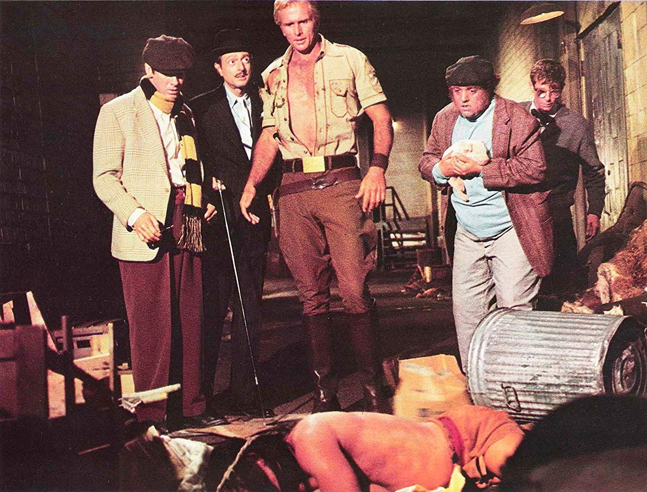 Doc and companions find a body - (l to r) Long Tom Roberts (Paul Gleason), Ham Brooks (Darrell Zwerling), Doc Savage (Ron Ely), Monk Mayfair (Michael Miller) and Johnny Littlejohn (Eldon Quick) in Doc Savage –The Man of Bronze (1975)