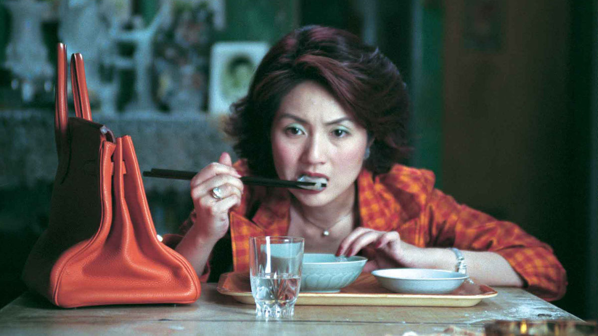 Miriam Yeung sits down to eat her dumplings in Dumplings (2004)