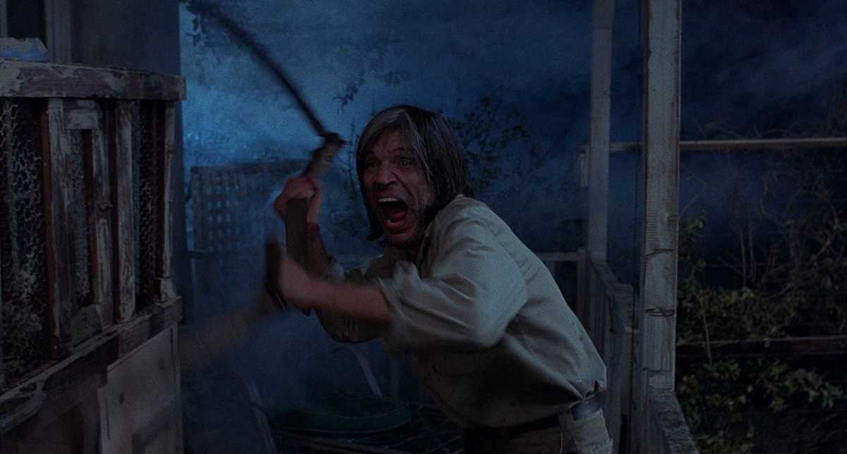 Mad scythe-wielding motelier Neville Brand in Eaten Alive (1977)