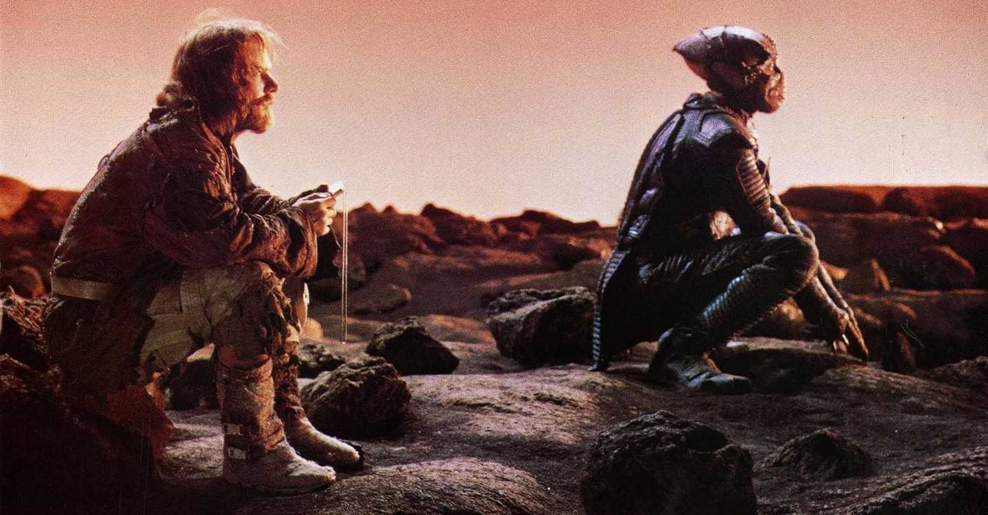 Human and alien enemies forced to cooperate for survival on a hostile planet - Davidge (Dennis Quaid) and Jeriba Shigan (Louis Gossett Jr) in Enemy Mine (1985)