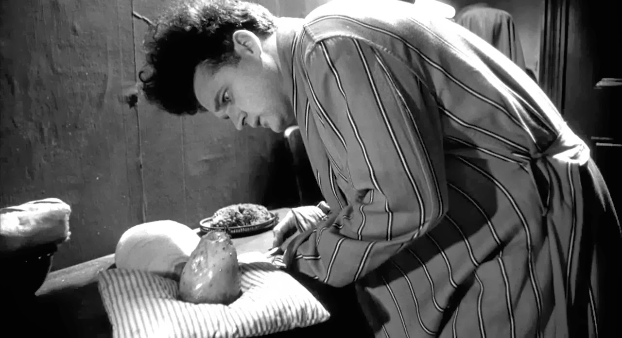 Henry (Jack Nance) left tending the baby in Eraserhead (1977)