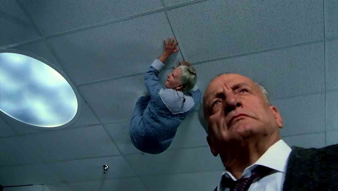 Lieutenant Kinderman (George C. Scott) investigates as seniors scuttle about on the ceiling in The Exorcist III (1990)