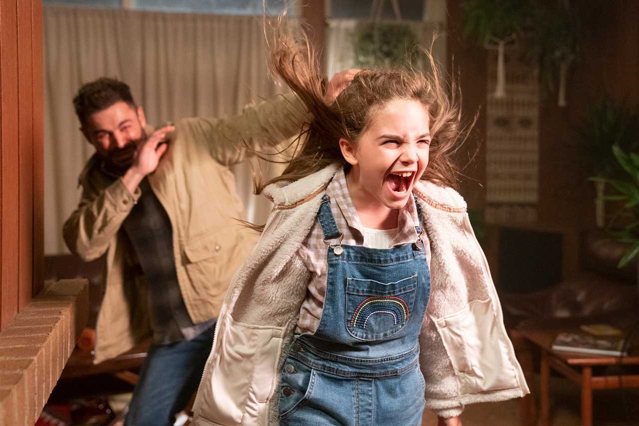 Charlie (Ryan Kiera Armstrong)'s powers erupt in Firestarter (2022). With Zac Eron in the background