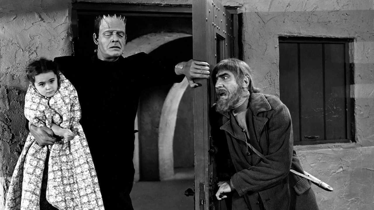 (l to r) The Frankenstein monster (Lon Chaney Jr) bursts in holding Janet Ann Gallow while Ygor (Bela Lugosi) waits behind the door in The Ghost of Frankenstein (1942)