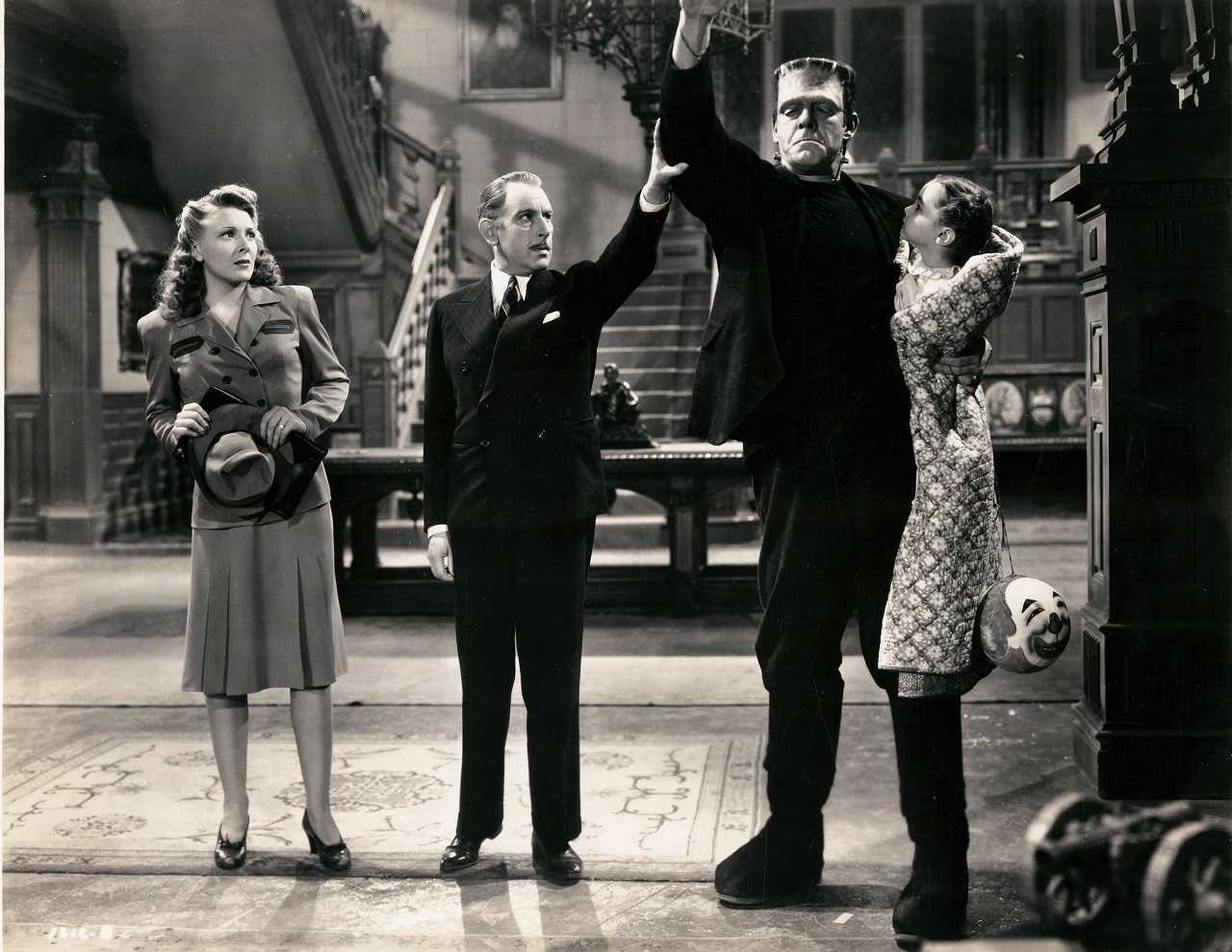 Ludwig Frankenstein (Cedric Hardwicke) accompanied by wife Elsa (Evelyn Ankers) introduces his monster (Lon Chaney Jr) holding Janet Ann Gallow in The Ghost of Frankenstein (1942)