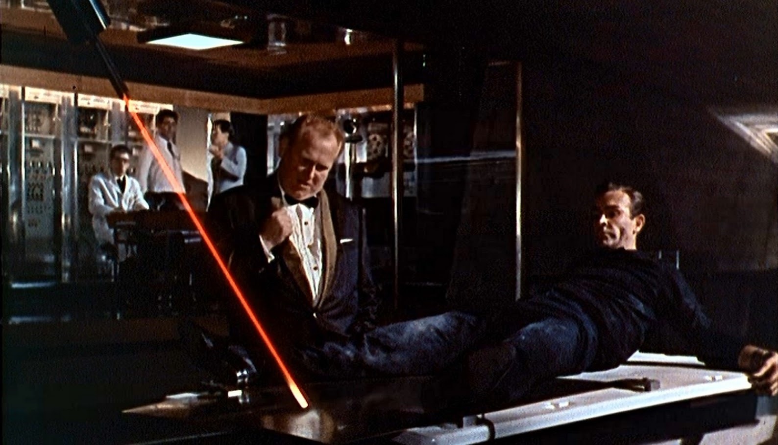 Goldfinger (Gert Frobe) with James Bond (Sean Connery) tied up in front of a laser in Goldfinger (1964)