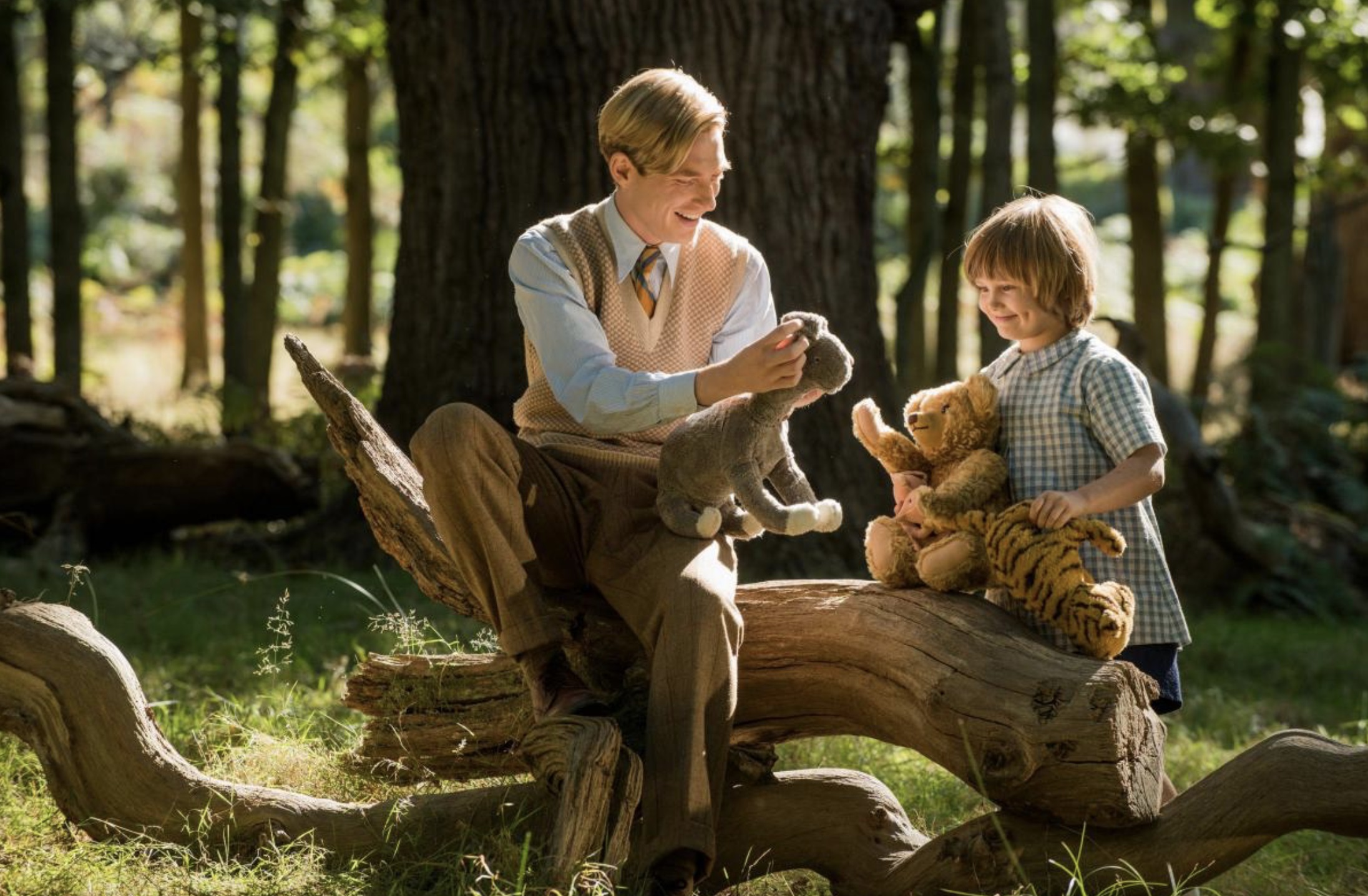 A.A. Milne (Domhnall Gleeson) and Christopher Robin (Will Tilston) play with the toys in Ashdown Woods in Goodbye Christopher Robin (2017)