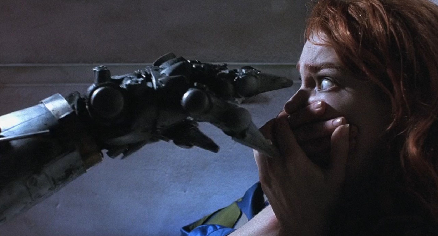 Stacey Travis under attack by a killer robot in Hardware (1990)