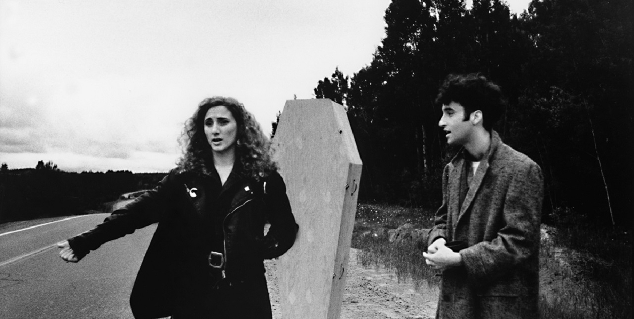 Valerie Buhagiar and Don McKellar go hitchhiking with a coffin in Highway 61 (1991)