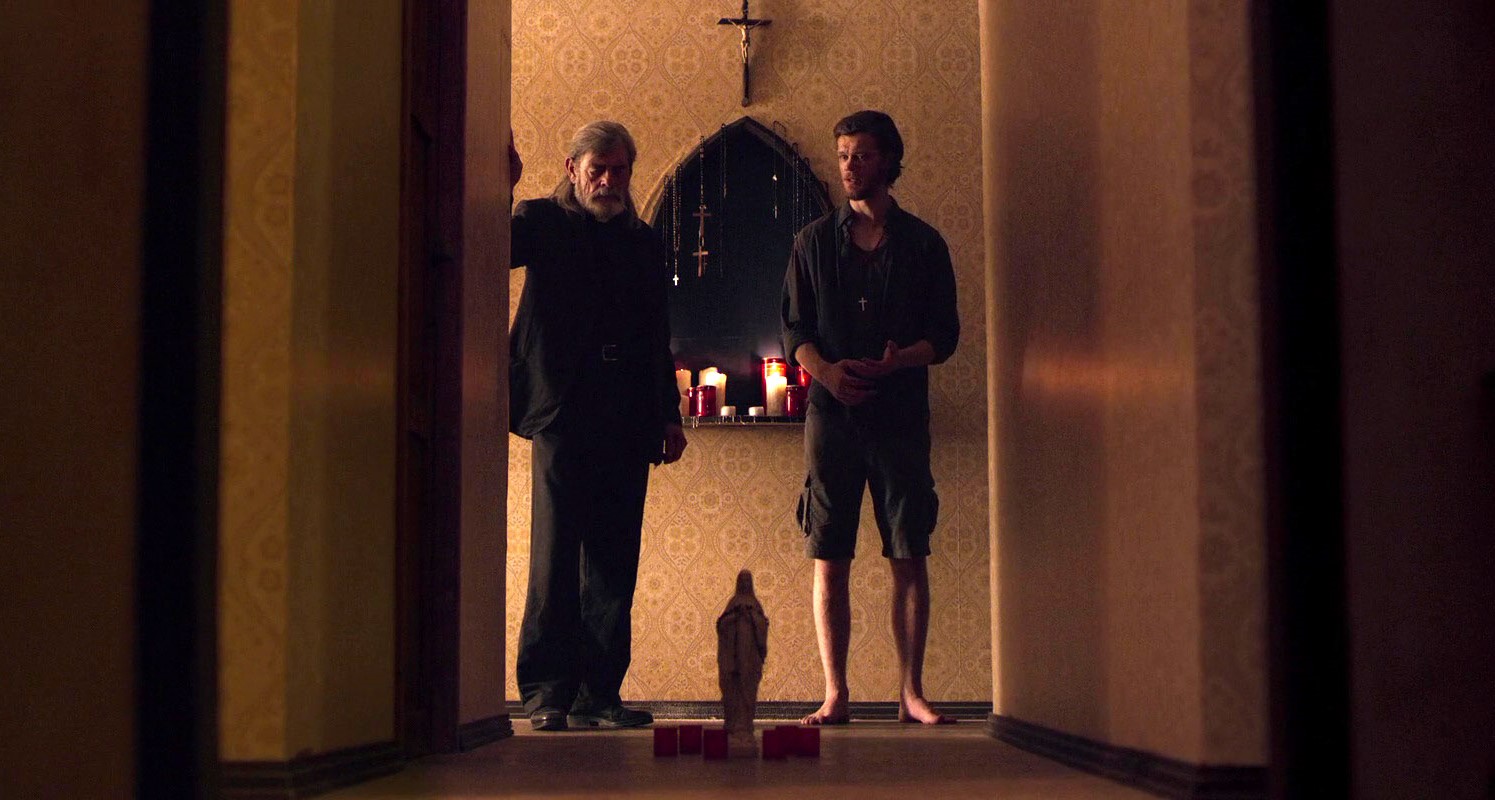 Father Andrew (David Bailie) and Philip (Jamie Paul) in In the Trap (2019)