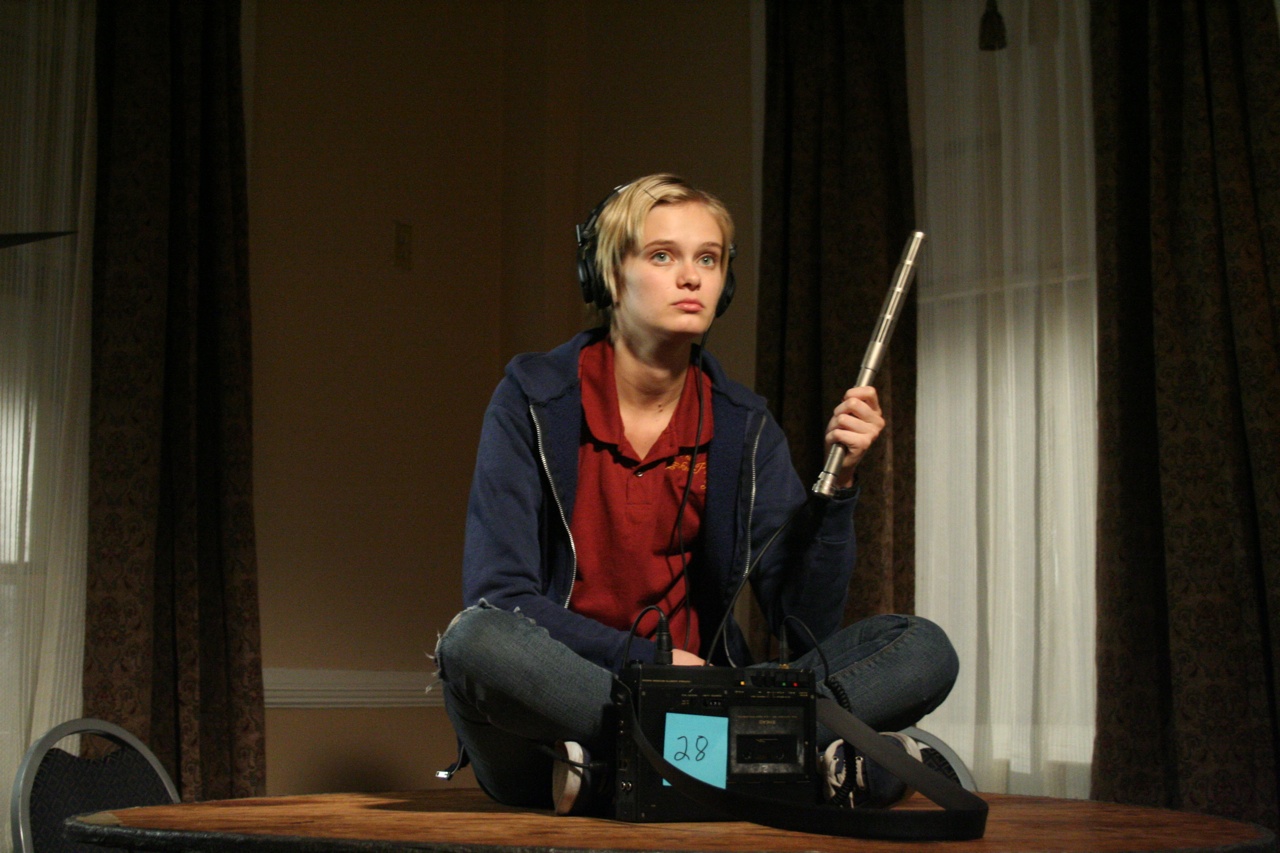 Sara Paxton sits listening with EVP equipment in The Innkeepers (2011)