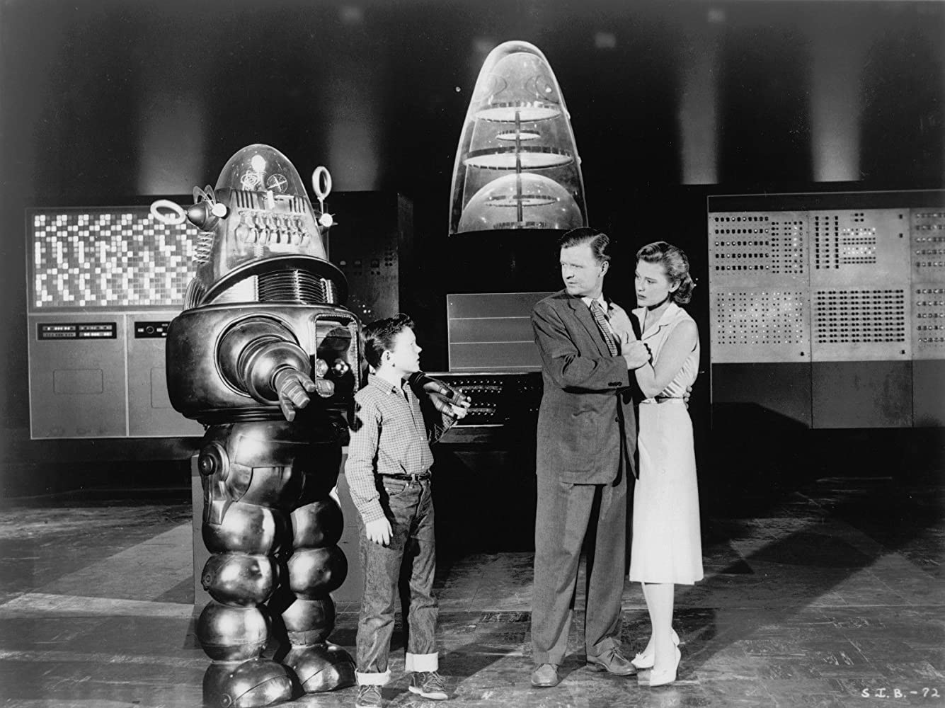 Robbie the Robot, young Richard Eyer and parents Phillip Abbott and Diane Brewster with Univac in the background in The Invisible Boy (1957)