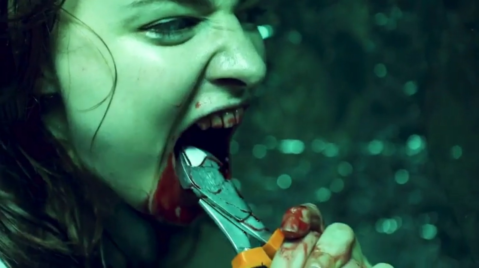 Alix Austin tears her teeth out with pliers in the It's Inside episode of Isolation (2021)