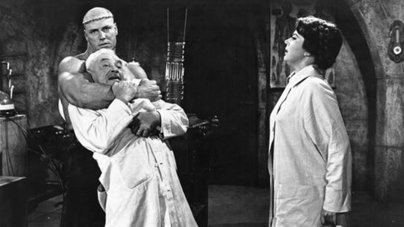 Maria Frankenstein (Narda Onyx) looks on as her monster Hank (Cal Bolder) strangles lab assistant William Fawcett in Jesse James Meets Frankenstein's Daughter (1966)