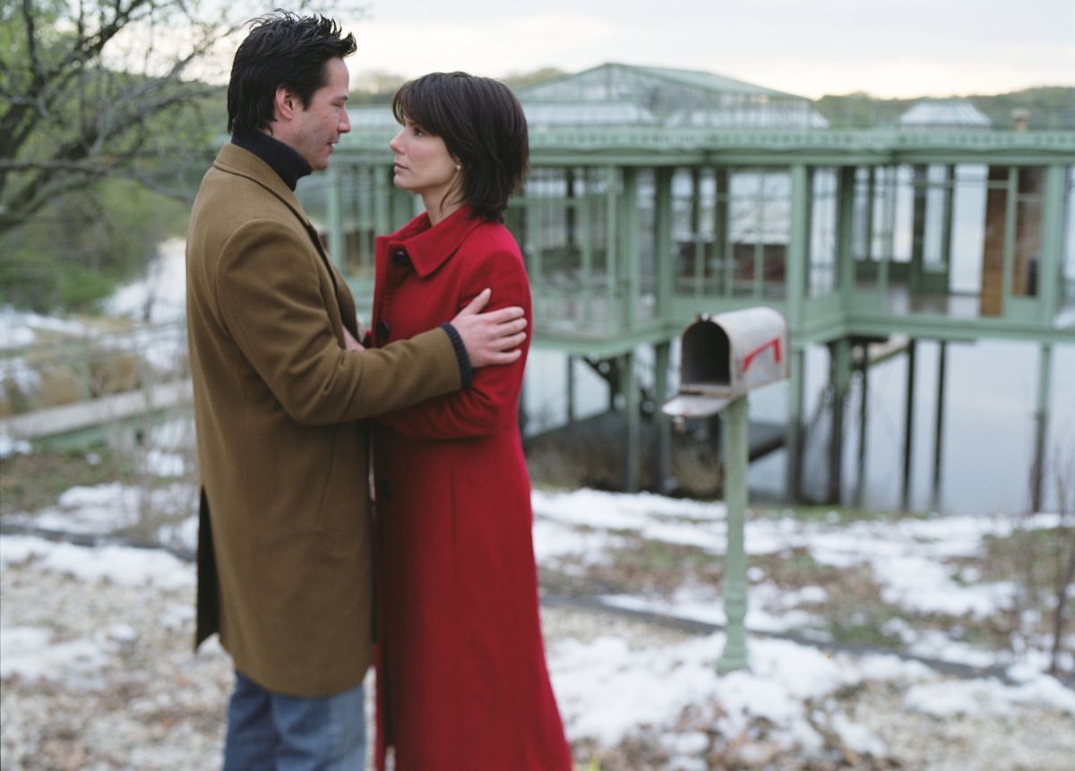 Keanu Reeves and Sandra Bullock with the lake house in the background in The Lake House (2006)