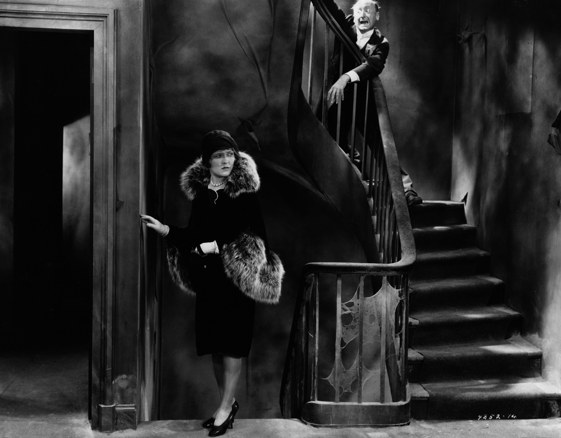 Heroine Laura La Plante while Burr McIntosh lurks at the top of the stairs in The Last Warning (1929)