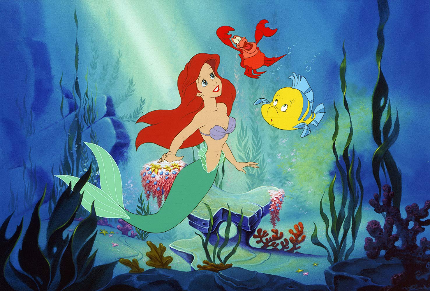 The mermaid Ariel (voiced by Jodi Benson) and her companions (l to r) the crab Sebastian (voiced by Samuel E. Wright) and Flounder (voiced by Jason Marin) in The Little Mermaid (1989)