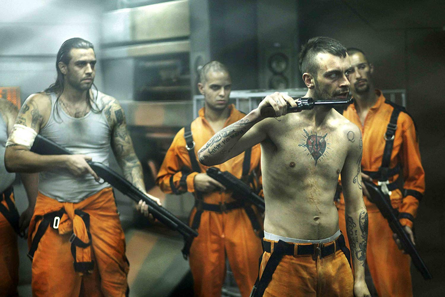 The psychopathic Hydell (Joseph Gilgun) (front) leads the prisoner's revolt in Lockout (2012)