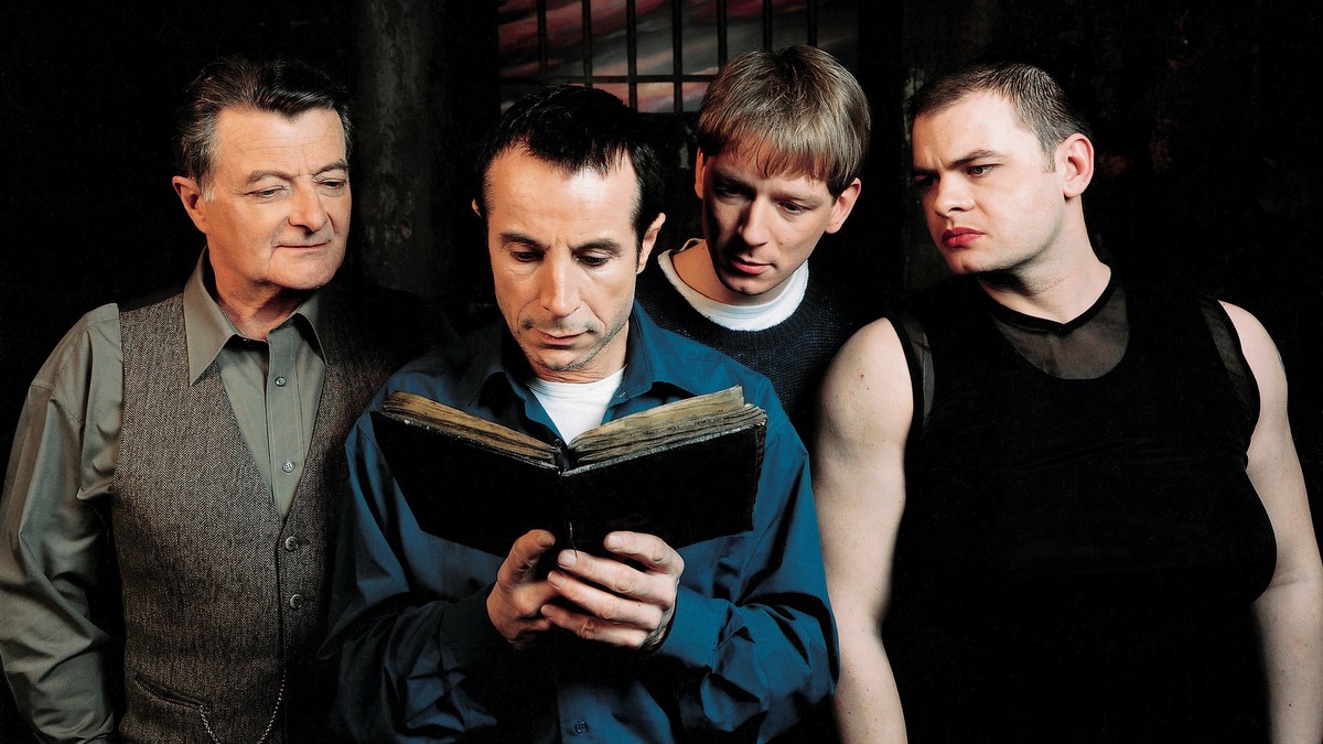 The prisoners - Lasalle (Philippe Laudenbach), Carrere (Gerald Laroche), Paquerette (Dimitri Rataud) and Marcus (Clovis Cornillac) - read from the occult book in Malefique (2002)