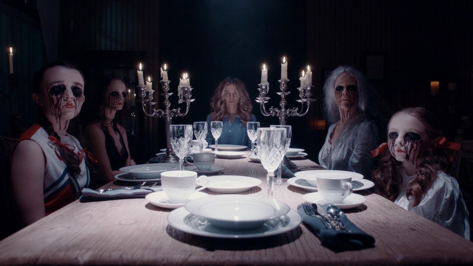 The ghosts around the table during the seance with Bojana Novakovic seated at the end centre in Malicious (2018)