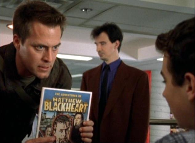 Matthew Blackheart (Robert Bogue) holds up a comic-book based on his exploits in Matthew Blackheart (2002)